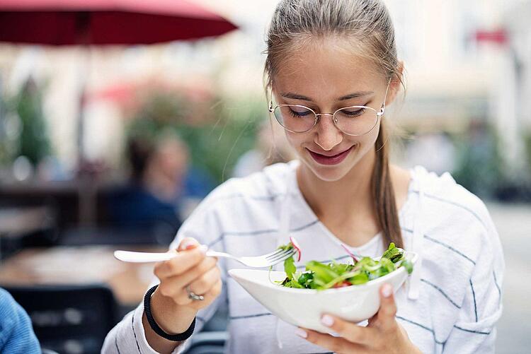 Jugendliche isst einen Salat