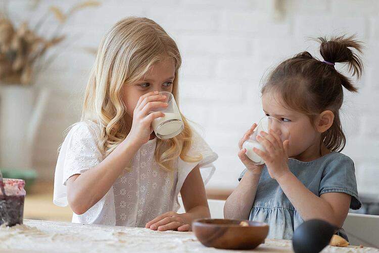 Zwei Mädchen trinken ein Glas Milch