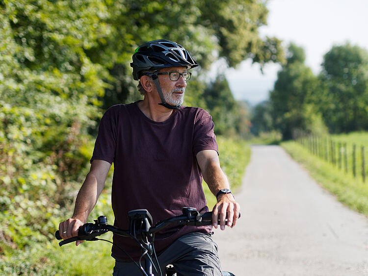 Mann fährt Fahrrad in der Natur.