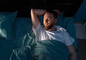 Mann schläft im Bett