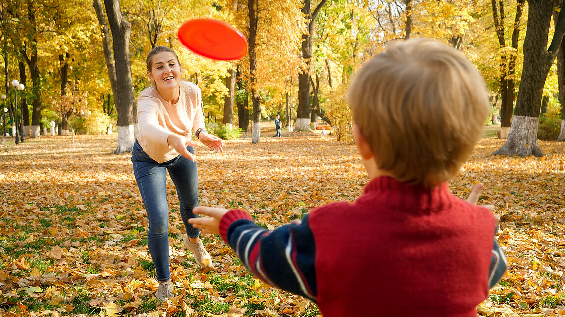 Mutter und Sohn spielen Frisbee