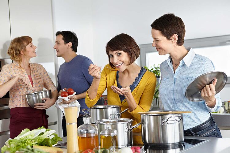 Zwei Pärchen kochen gemeinsam.