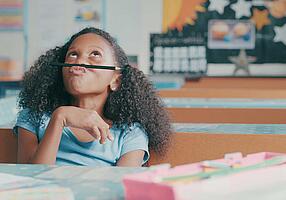 Mädchen spielt in der Schule gelangweilt mit einem Bleistift