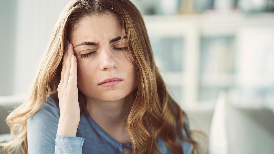 Frau greift sich an die schmerzende Schläfe - Bildnachweis: © istockphoto.com / seb_ra Frau greift sich an die schmerzende Schläfe