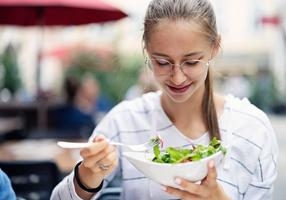 Jugendliche isst einen Salat