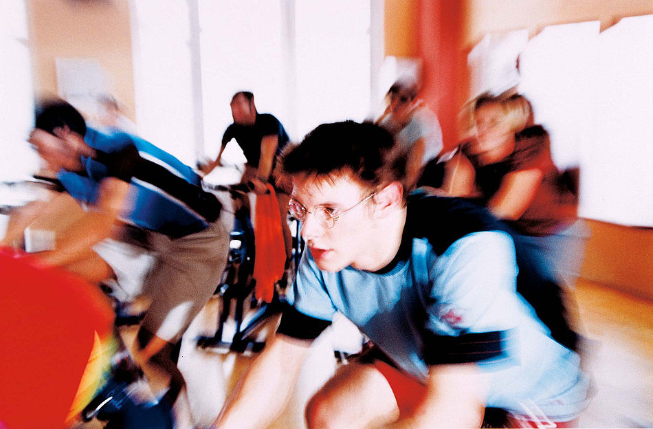 Gruppe in einem Fitnessstudio beim Spinning-Training.