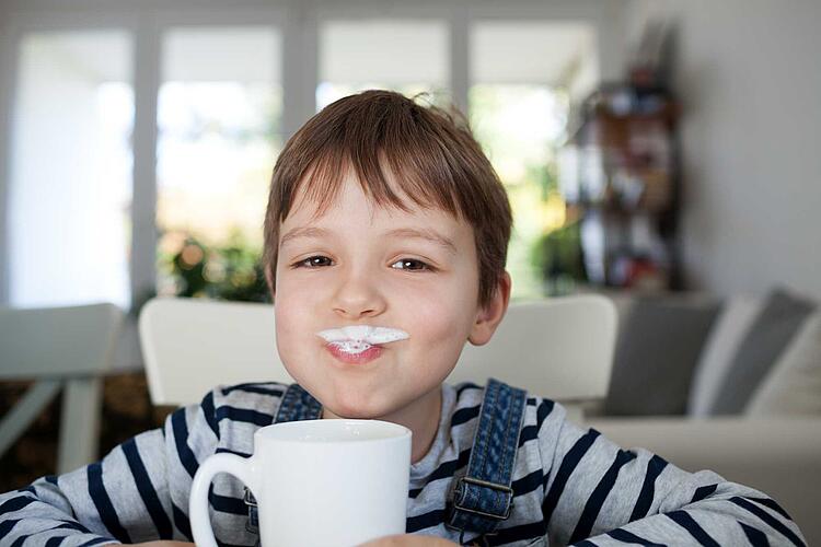 Junge trinkt eine Tasse Milch
