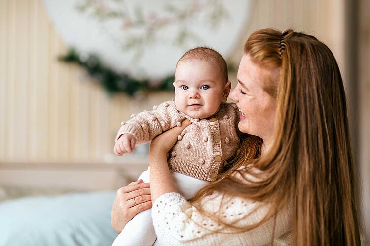 Frau mit Baby auf dem Arm.