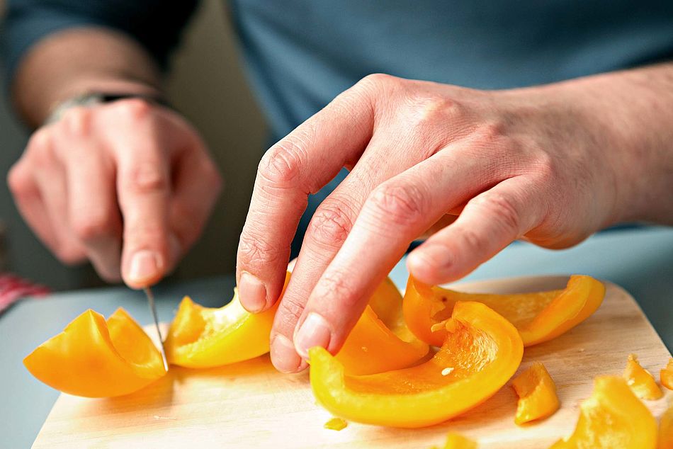 Männerhände schneiden gelbe Paprikaschoten klein. - Bildnachweis: © wdv / Jan Lauer Männerhände schneiden gelbe Paprikaschoten klein.