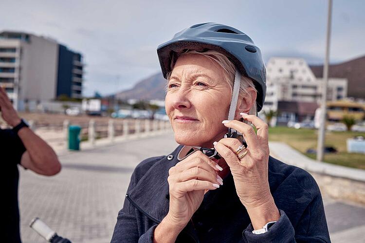 Frau schließt ihren Fahrradhelm