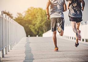 Zwei Jogger auf einer Brücke