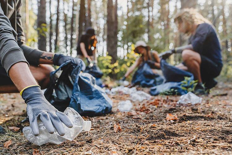 Gruppe sammelt Plastikmüll im Wald