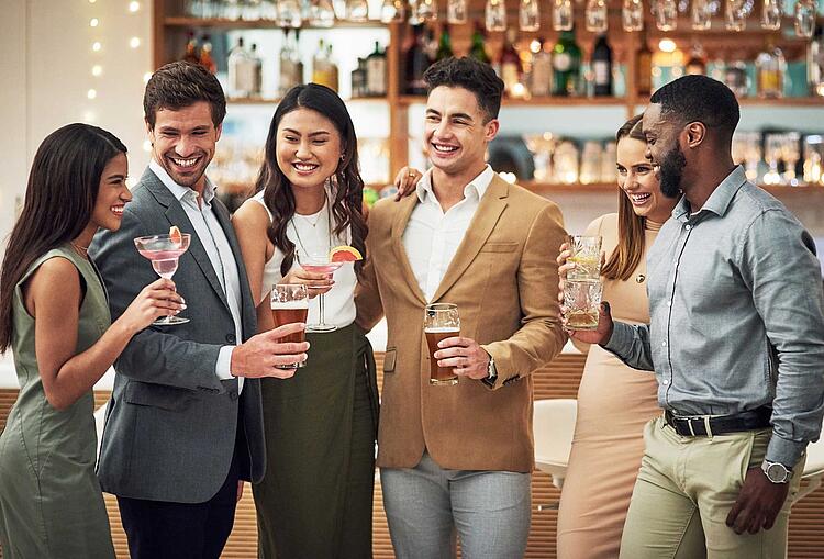 Gruppe mit alkoholischen Getränken in der Hand in einer Bar