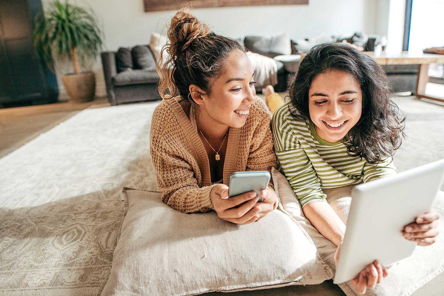 Zwei junge Frauen mit Laptop und Smartphone