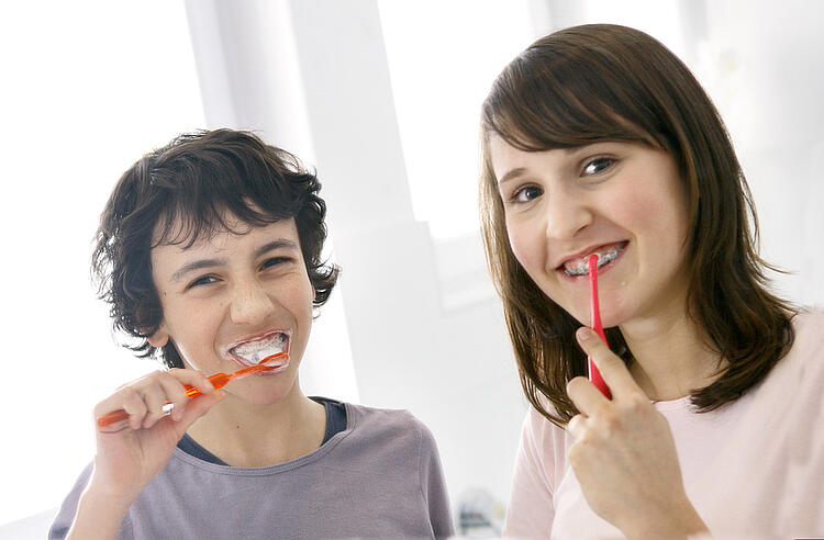 Junge und Mädchen beim Zähne putzen.