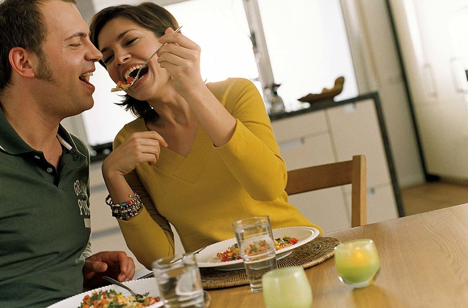 Ein Paar beim Essen, sie füttert ihn und beide lachen. - Bildnachweis: © wdv / Frank Blümler Ein Paar beim Essen, sie füttert ihn und beide lachen.