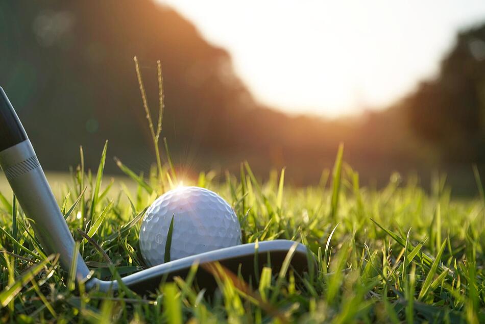Golfschläger und Golfball auf dem Rasen