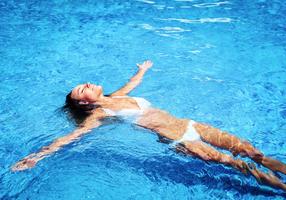 Frau liegt im Wasser auf dem Rücken