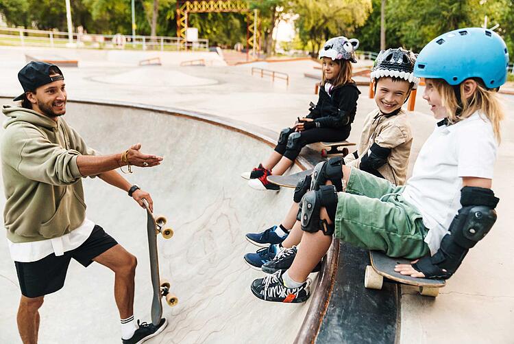 Kinder mit Schutzkleidung beim Skateboardfahren