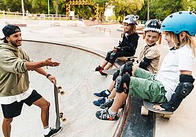 Kinder mit Schutzkleidung beim Skateboardfahren