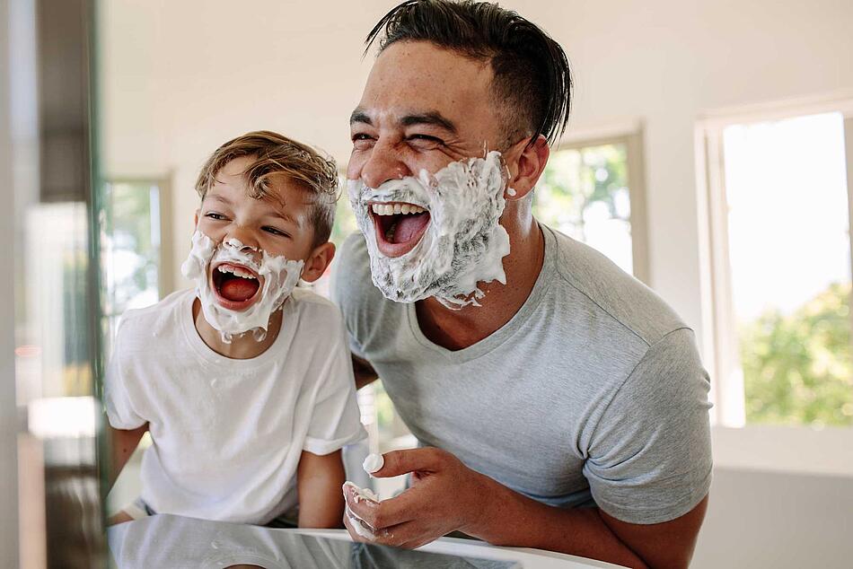 Vater und Sohn haben Spaß beim Rasieren