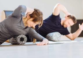 Mann und Frau machen Übungen mit der Faszienrolle