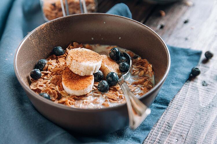 Buntes Früchte-Müsli in einer Schüssel mit Löffel.