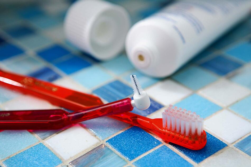 Zahnbürste, Zahnzwischenraumbürste und eine Tube Zahncreme.