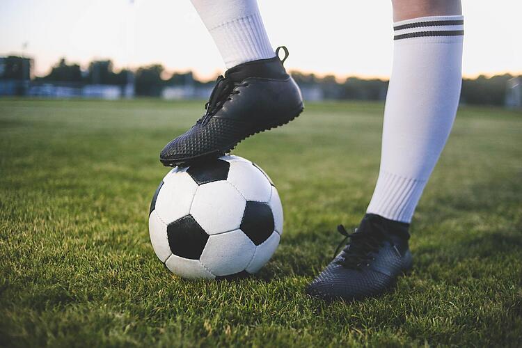 Fuß steht auf einem Fußball