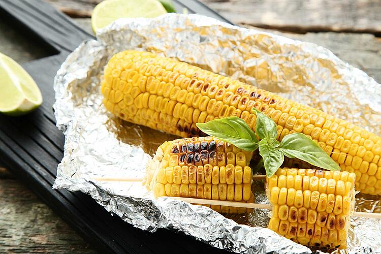 Gegrillte Maiskolben auf Alufolie.