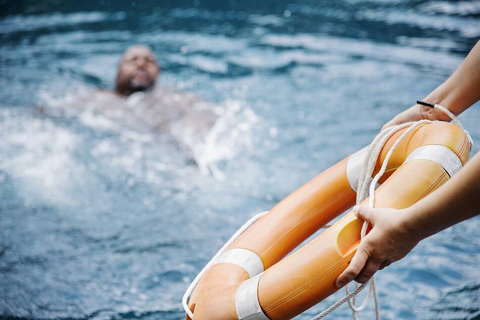 Frau wirft Mann Rettungsring zu