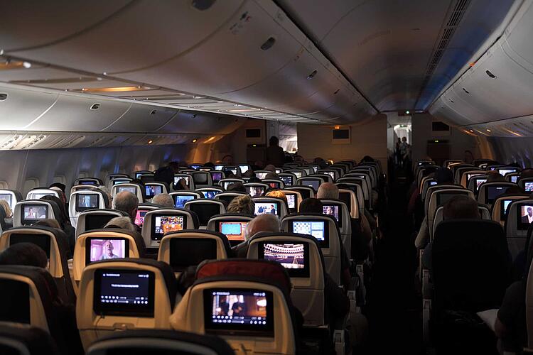 Passagiere schauen Filme auf einem Langstreckenflug