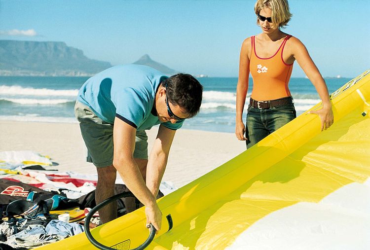 Junges Paar am Strand baut arbeitet an einem Windsurfsegel. - Bildnachweis: © wdv / Mathias Stalter Junges Paar am Strand baut arbeitet an einem Windsurfsegel.