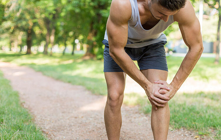 Jogger fasst sich an sein schmerzendes Knie