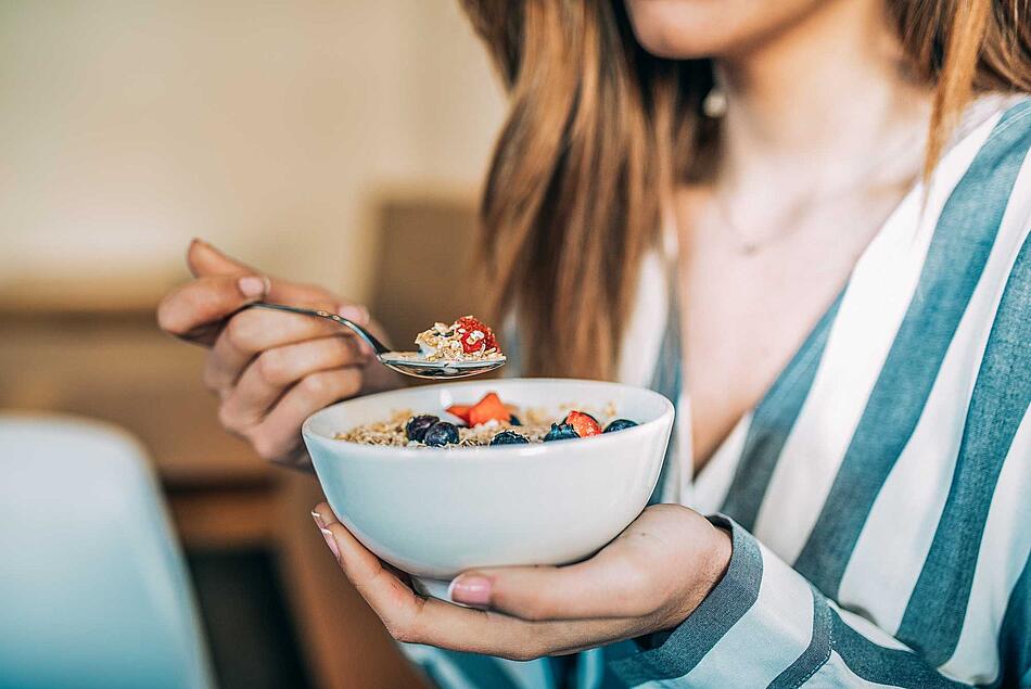Frau isst Müsli mit Obst - Bildnachweis: © istockphoto.com / David-Prado Frau isst Müsli mit Obst