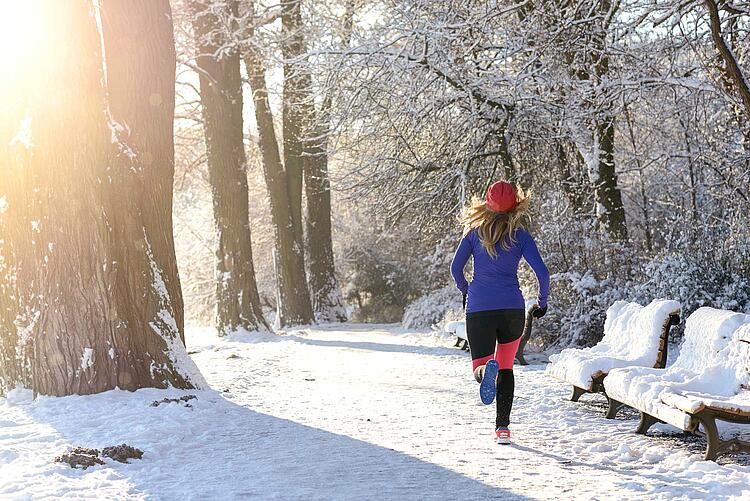 Frau joggt im Schnee