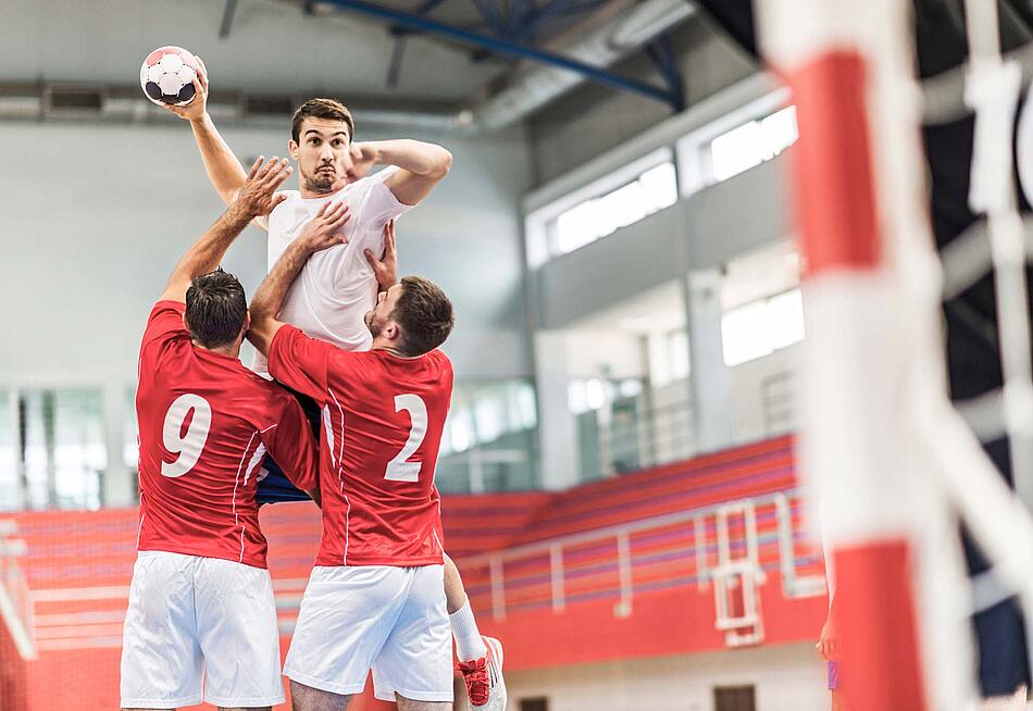 Handballspieler wirft den Ball auf das Tor.