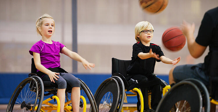 Kinder im Rollstuhl beim Basketball-Training.