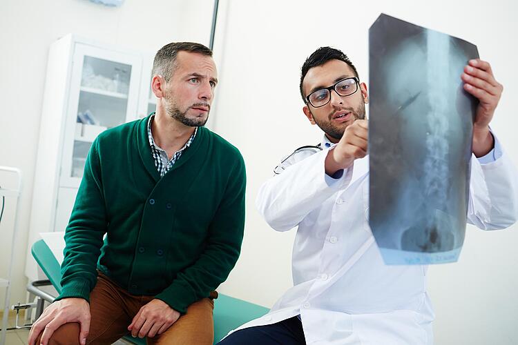 Arzt zeigt einem Patienten ein Röntgenbild