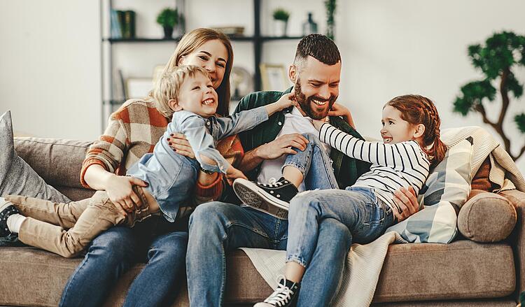 Familie kuschelt auf dem Sofa