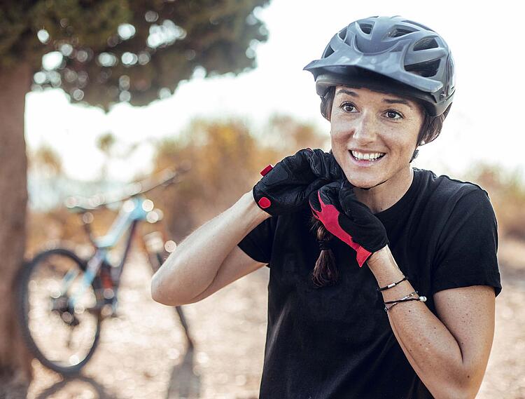 Frau öffnet ihren Fahrradhelm.