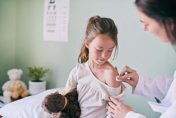 Ein kleines Mädchen wird von einer Ärztin geimpft.