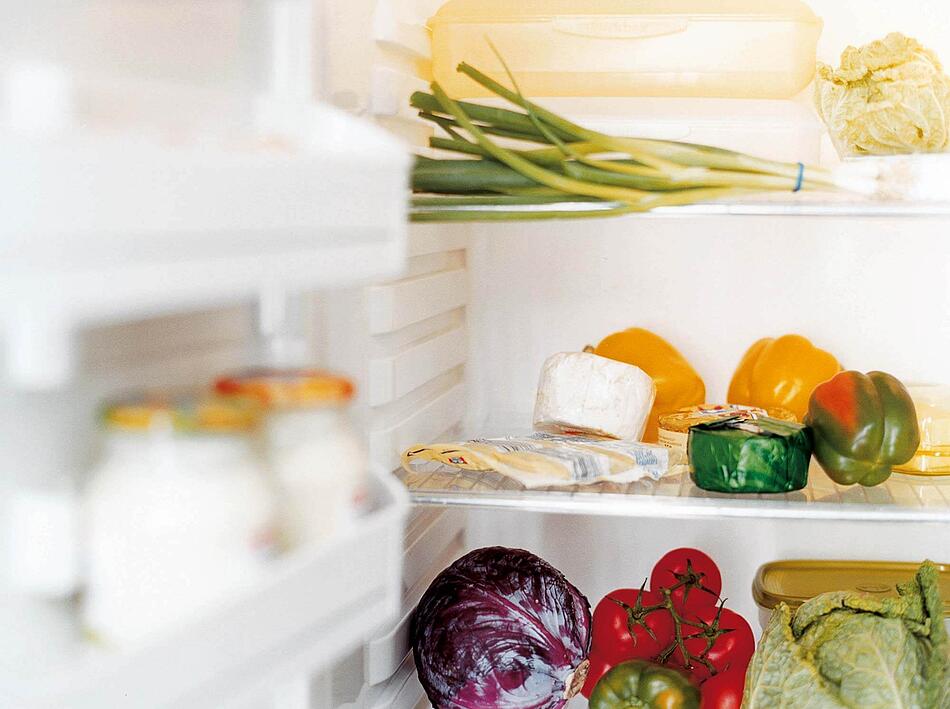 Ein offener Kühlschrank mit Gemüse, Käse und Milchprodukten.