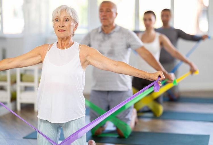 Rücken stärken mit dem Theraband, Gruppe im Fitnessstudio