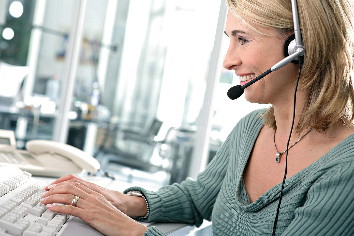 Frau mit Headset am Computer.