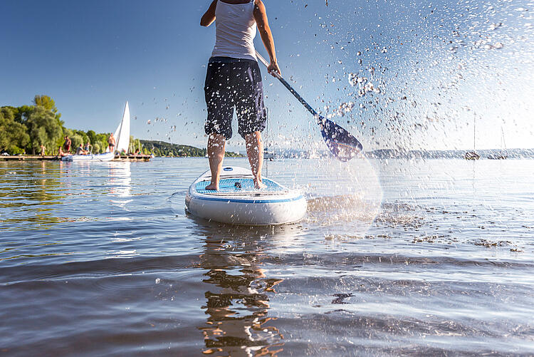 Frau beim Standup-Paddling auf einem See.