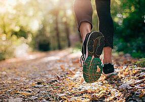 Joggende Füße einer Person im Wald