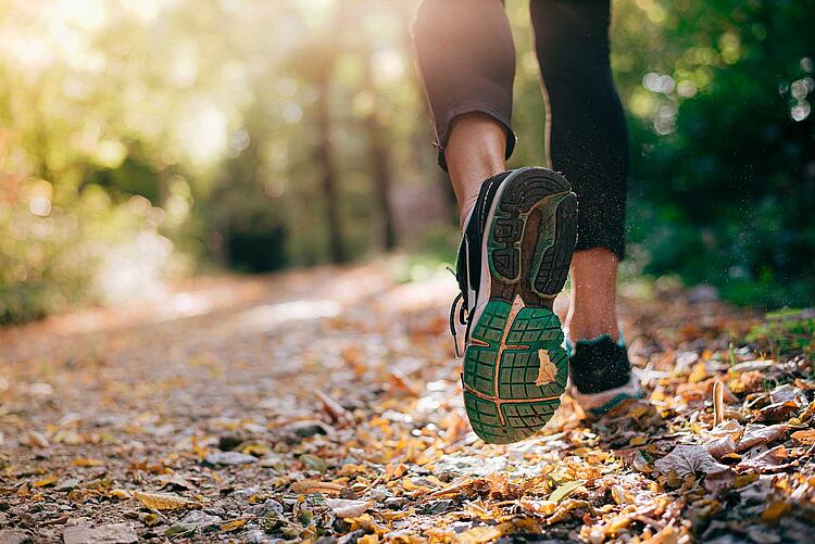 Joggende Füße einer Person im Wald