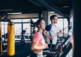 Mann und Frau laufen im Fitnessstudio auf dem Laufband