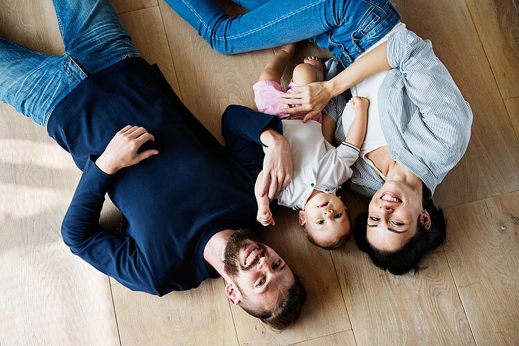 Familie liegt auf dem Teppich